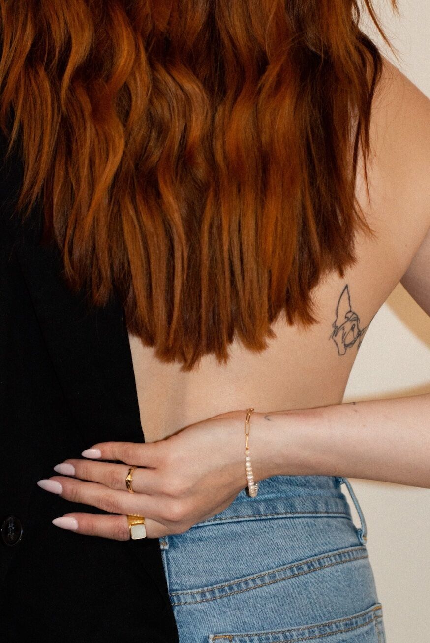 Back view — rings, signet, pearl bracelet, denim