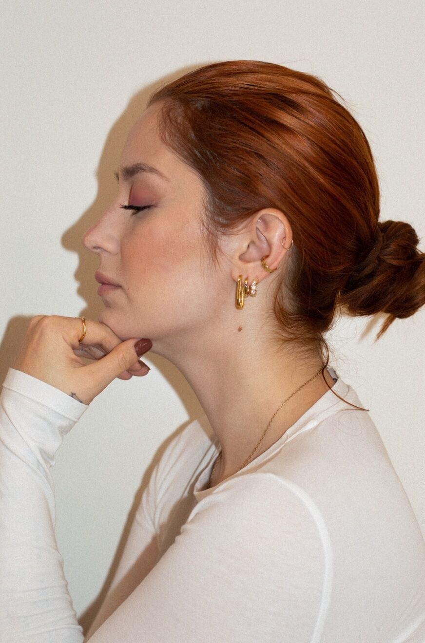 Model with low bun and gold hoops
