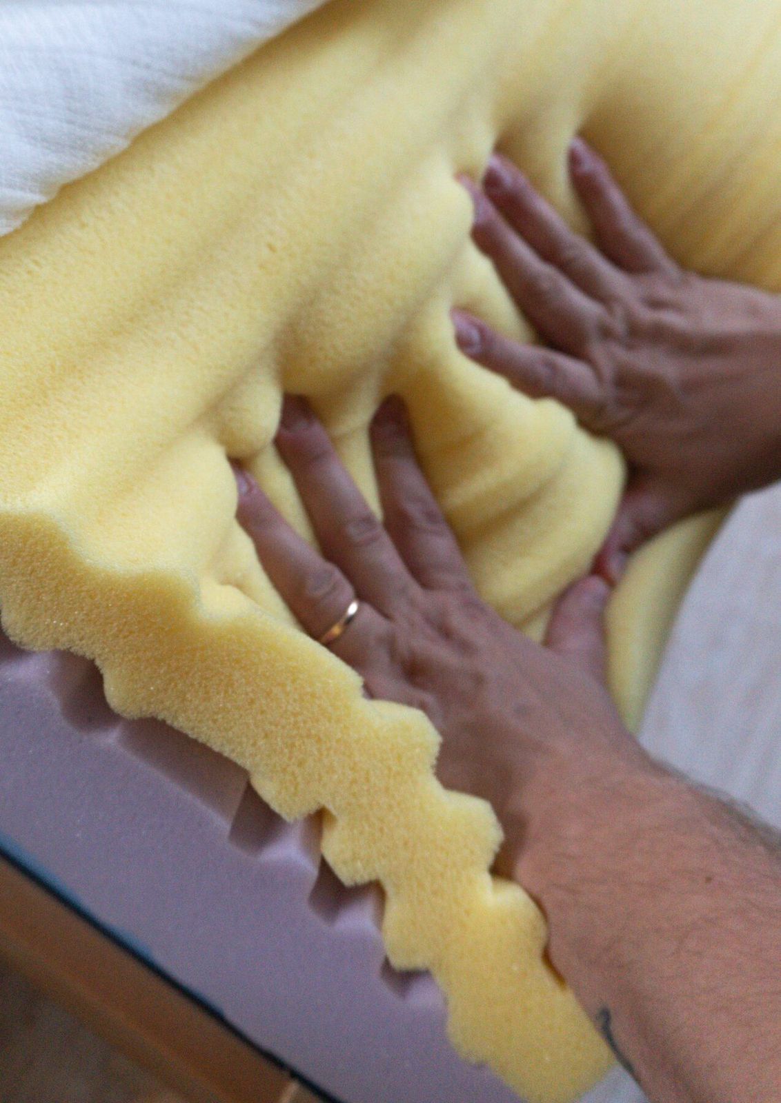 Hands testing pressure response of yellow foam
