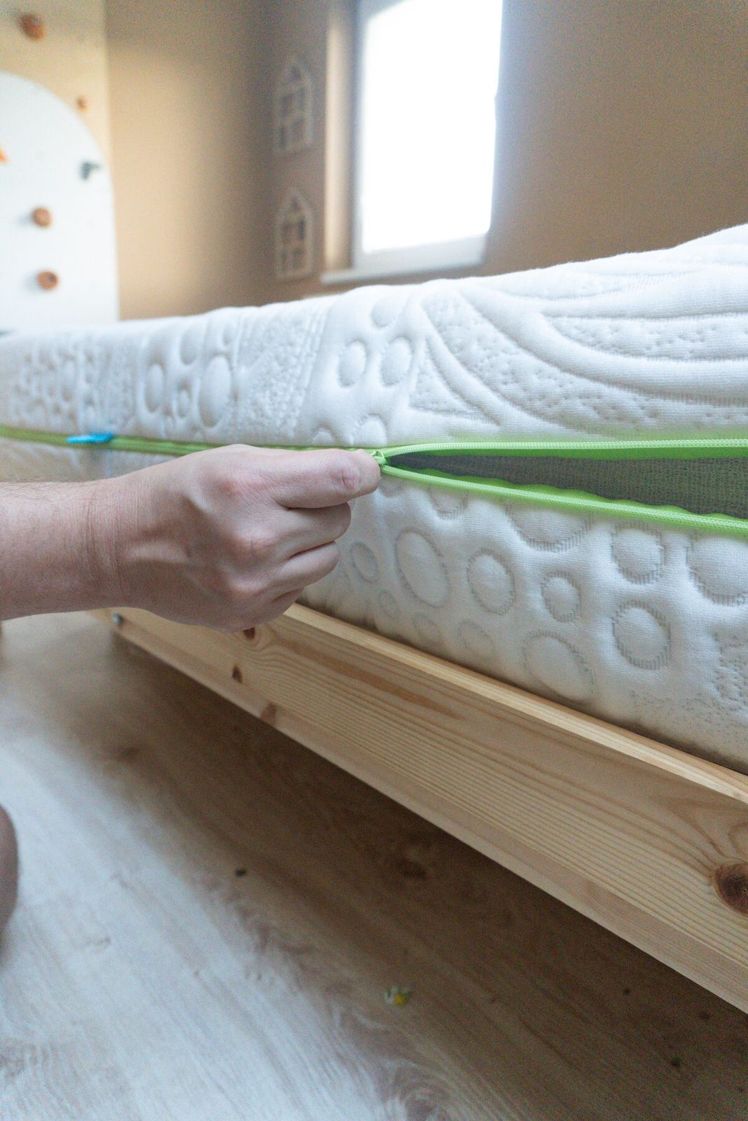 Hand opening green zipper of mattress cover