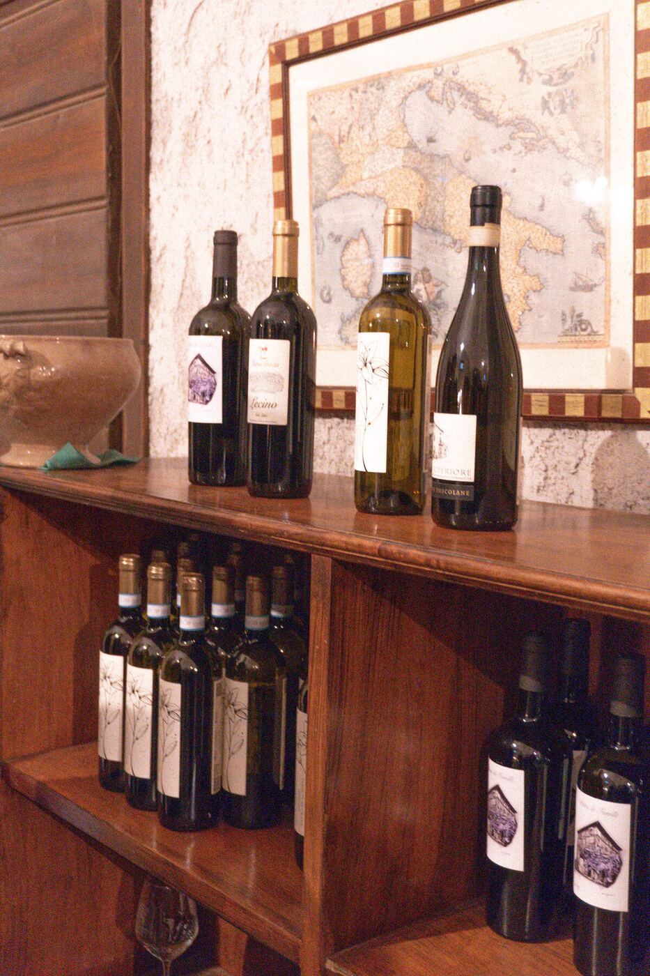Bottles displayed beneath an antique Italy map