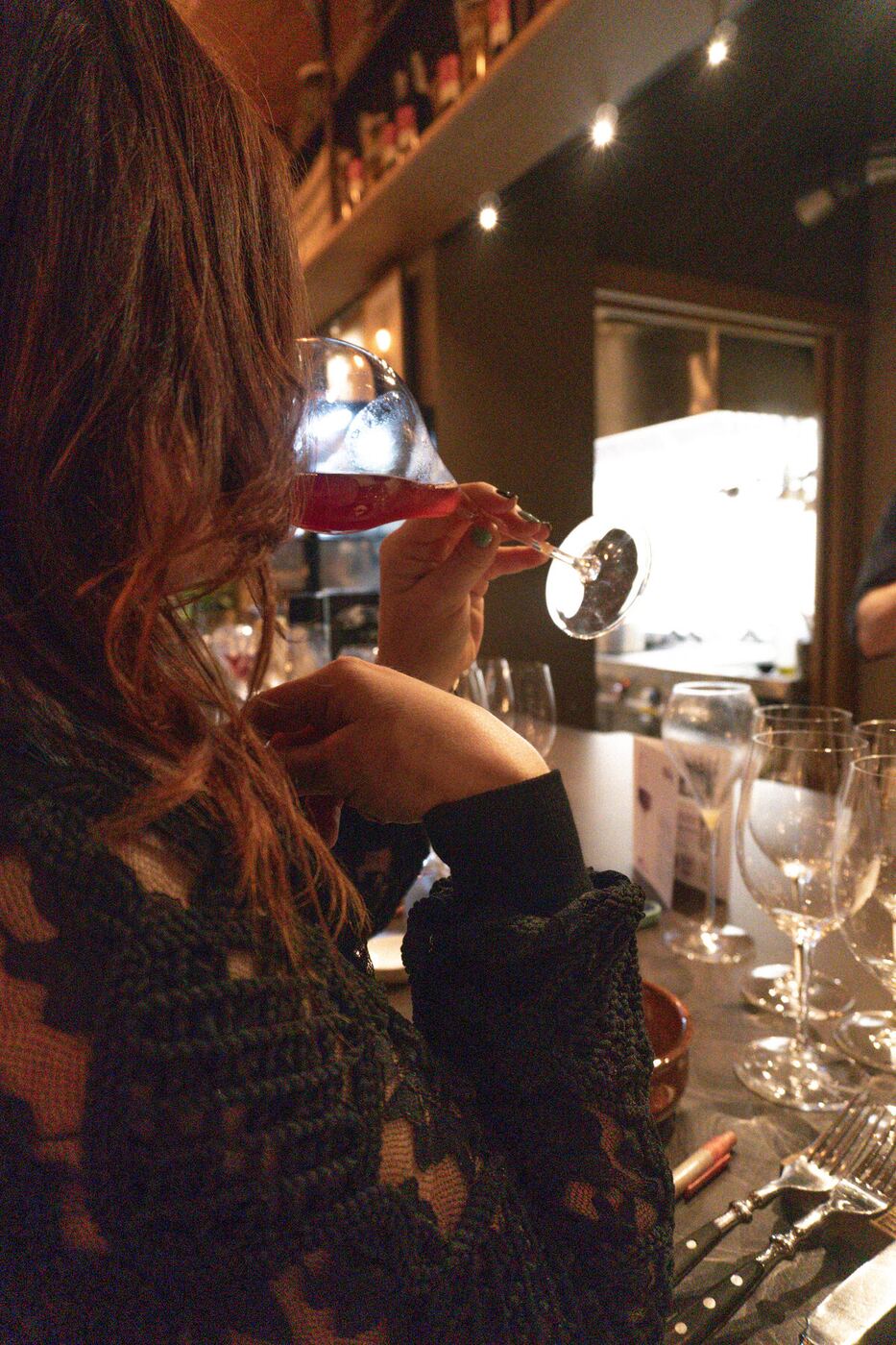 Holding a glass of red wine in candlelight